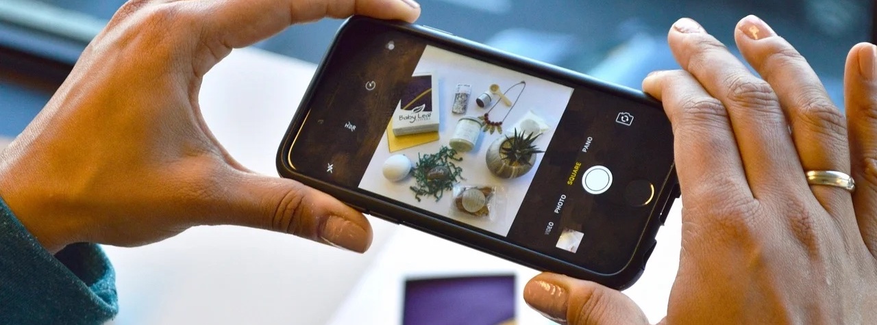 iPhone taking photo of plants and books on a table